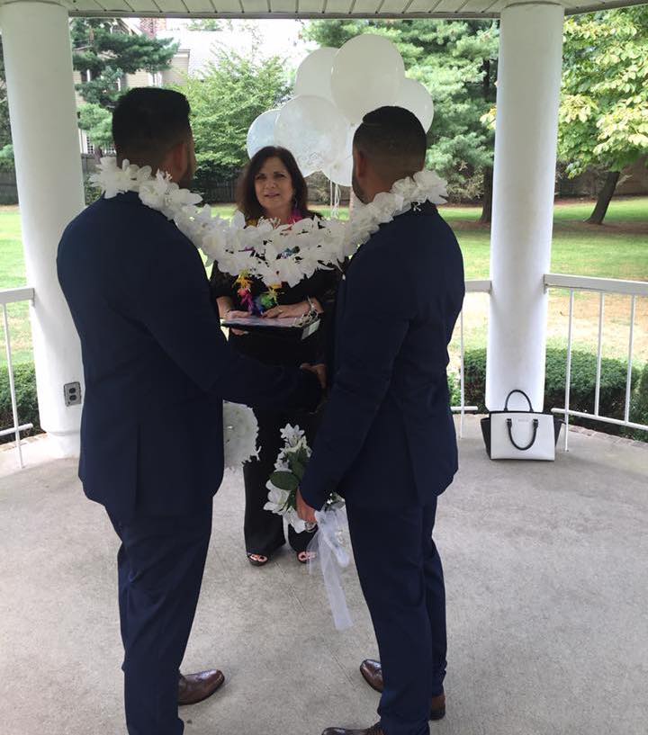 Two long island wedding officiants in suits standing next to each other at a wedding ceremony.