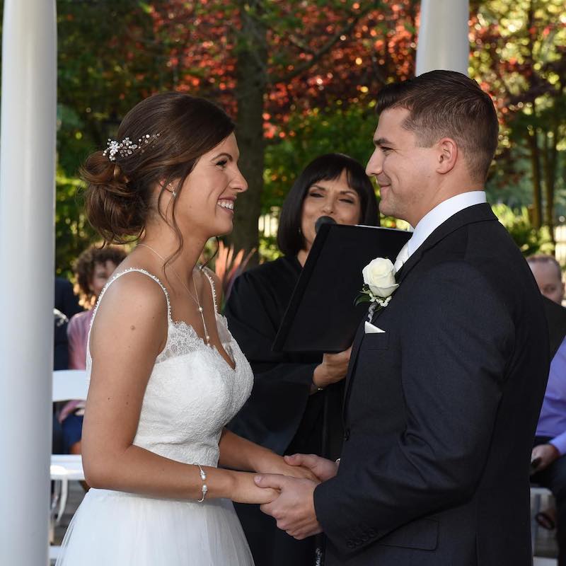 A bride and groom smiling at each other during their long island wedding ceremony officiated by a long island wedding officiant.