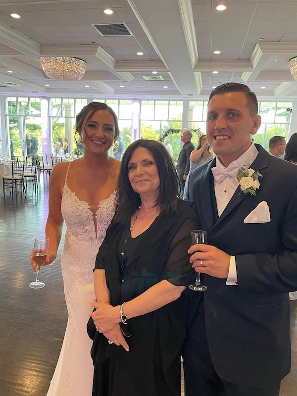 A man and woman, along with the wedding officiant in Long Island, posing for a photo at a wedding.