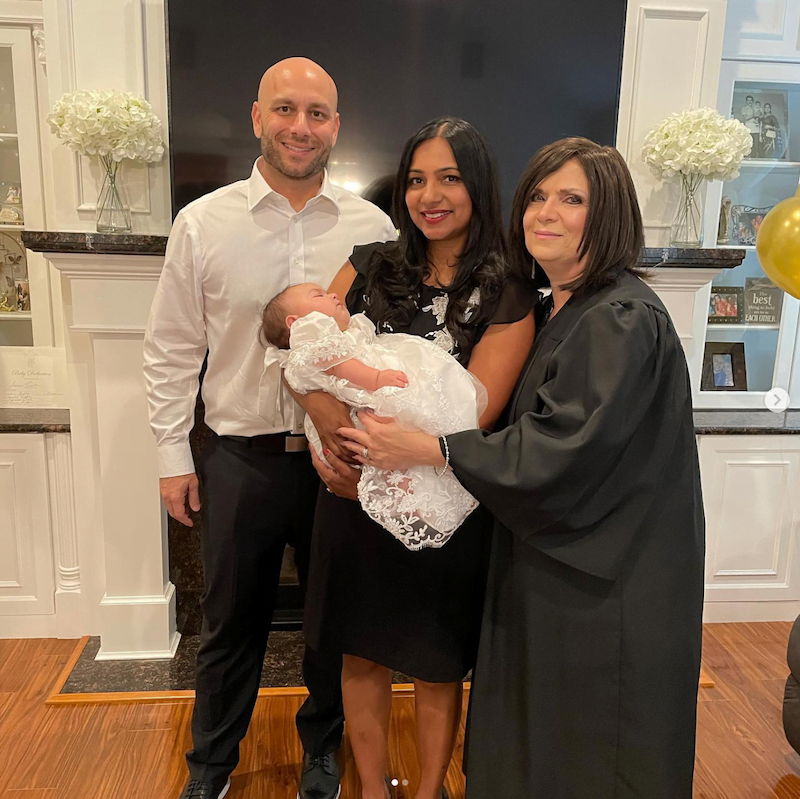 A woman and a man posing with a baby while being officiated by a professional officiant in Long Island.